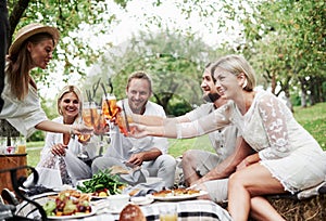 United for years. Group of adult friends have a rest and conversation in the backyard of restauraunt at dinner time