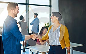 Uniting their strengths to fast forward to success. businesspeople shaking hands in an office.