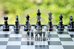 Unity and teamwork in business strategy concept, group of miniature people businessmen collaborate help and work as