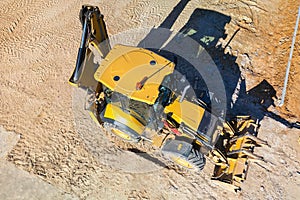 Universal excavator or loader with folded bucket at construction site. Universal construction equipment. Rental of construction