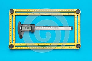 Universal measuring ruler and electronic vernier caliper on a blue background