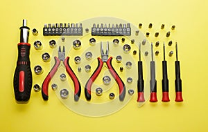 A universal set of screwdrivers with replaceable nozzles on a light yellow background.