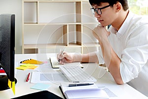 University / college student doing homework in classroom, education concept