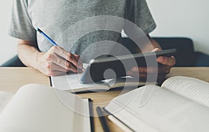 University or college student using tablet for studying, learning or reading textbook online at home. Success idea of self