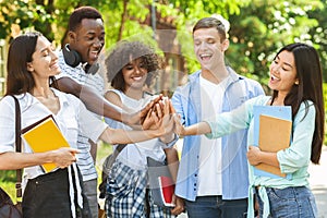 University Friendship. Portrait Of Joyful International Students Joining Hands Outdoors
