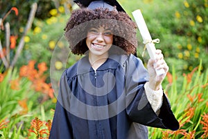 University, graduation and portrait of happy woman with diploma for education, achievement or success ceremony on campus