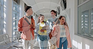 University, group and students walking on campus for education together in a corridor as friends with a scholarship