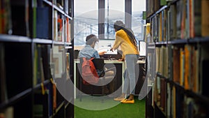 University Library: Boy Uses Personal Computer at His Desk, Talks with Girl Classmate who Explains