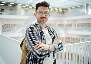 University, portrait and man student in the library for studying, learning or knowledge with books. Education, bookstore