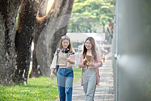 University student girl friends with learning book college while walking in campus