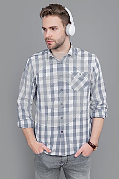 University student listening to audio courses in headphones. Serious guy learning by listening