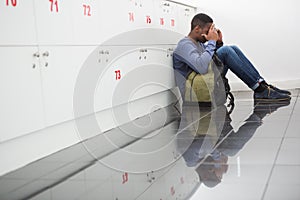 University student sitting alone with his hands on face