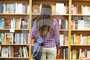 University student standing in the bookcase photo