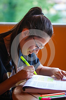 University student studying for an exam underlining text with highlighter