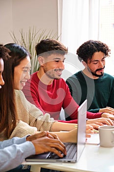 University student studying with his colleagues together at shared flat.