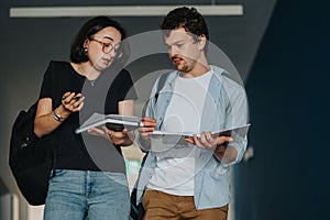 University students discussing coursework in a hallway setting