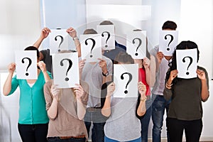 University students holding question mark signs