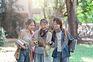 university students using a digital tablet while walking to next class