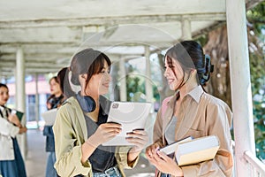 university students using a digital tablet while walking to next class. back to school concept