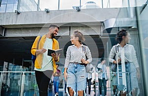 University students walking in the corridor indoors, talking.