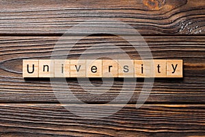 UNIVERSITY word written on wood block. UNIVERSITY text on wooden table for your desing, concept