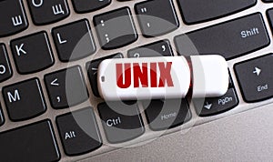 UNIX - the word on a white flash drive, lying on a black laptop keyboard photo