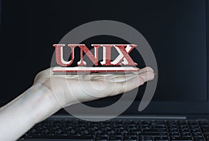 UNIX - word on a woman`s hand against the background of a laptop