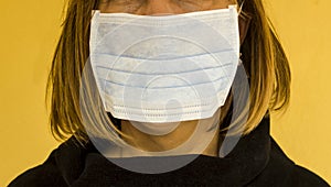 Unknown adult female is using single use hygenic face mask photo