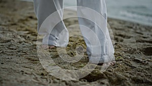 Unknown barefoot man stepping on beach closeup. Athlete exercising on seacoast