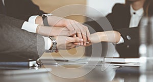 Unknown business people group joining hands in modern office. Businessmen and women making circle with their hands as a