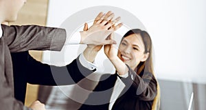 Unknown business people group joining hands in modern office. Businessmen and women making circle with their hands as a