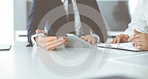 Unknown business people using tablet computer in modern office. Businessman or male entrepreneur is working with his