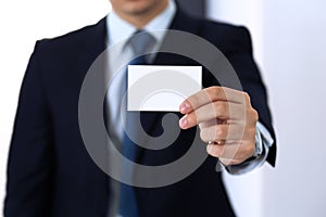 Unknown businessman hand holding business card with empty space, close-up
