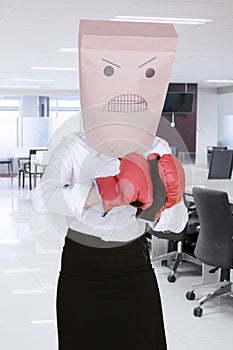 Unknown businesswoman wearing boxing gloves