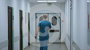 Unknown doctor walking down hospital corridor. Surgeon hurring to operation.