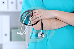 Unknown female doctor holds stethoscope closeup. Physician ready to examine and help patient. Medical help and insurance