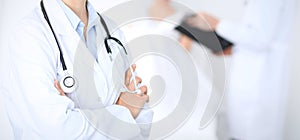 Unknown female doctor with medical staff at hospital. Closeup of stethoscope