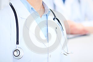 Unknown female doctor with medical staff at hospital. Teamwork in medicine