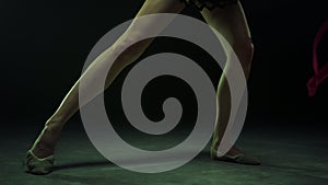 Unknown female legs practicing artistic gymnastics. Gymnast performing ribbon.