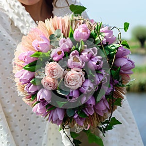 Unknown girl holding beautiful gentle bouquet with pink and purp
