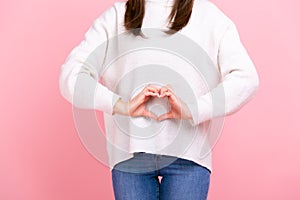 Unknown girl making heart shape in front of her belly as symbol of women health care, healthy eating