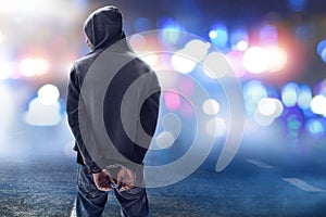 Unknown hacker in handcuffs on the street photo