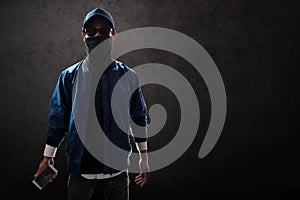 Anonymous hacker holding mobile phone