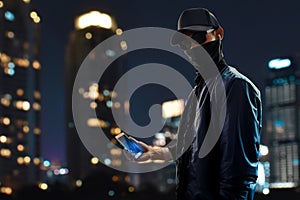 Hacker holding mobile phone