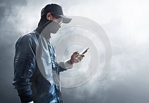 Anonymous hacker using mobile phone