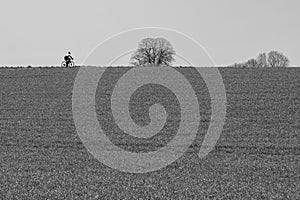 The unknown lonely cyclist through the Dutch landscape in the Dutch hillside of south Limburg and Heuvelland