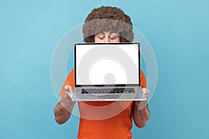 Unknown man holding laptop in hands, hiding half of his face, copy space for promotion, looking down