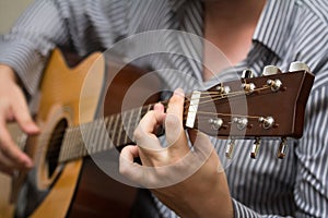 Unknown man playing an acoustic guitar