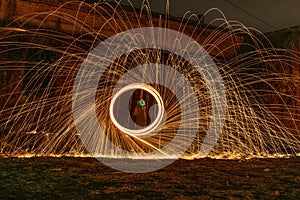 Unknown person with a dead face icon making a steel wool effect with light sparks