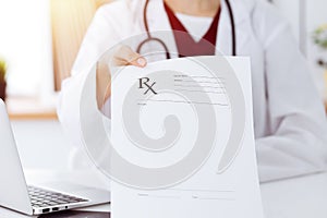 Unknown woman-doctor pointing into empty prescription form record close-up. Medicine concept